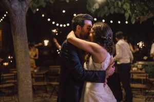 Beso de una pareja de novios durante la fiesta bajo las estrellas